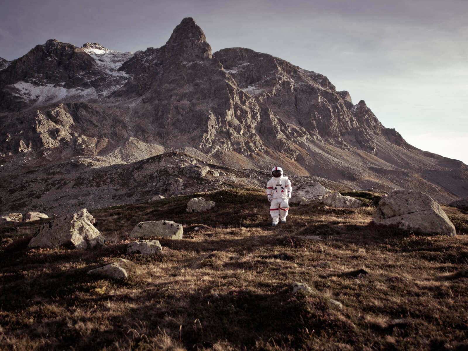 An astronaut walks a rugged mountain path, inviting us to discover new worlds. Just like bold careers at Decho with Palantier technologies.